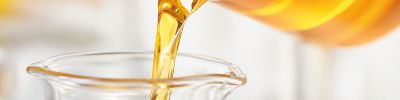 Fötales Kälberserum (mit charakteristisch goldener Farbe) wird von einem Becherglas umgefüllt
