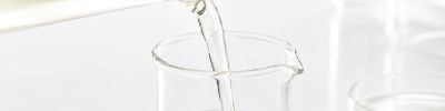 Zellkulturmedium ohne Phenolrot wird von einem Becherglas in ein anderes Becherglas geschüttet
